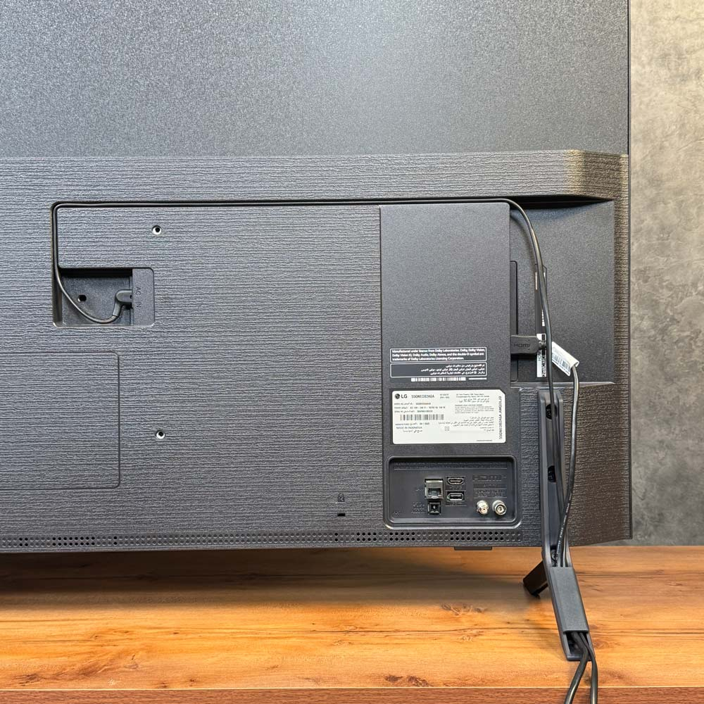 نمای پشتی تلویزیون ال‌ جی QNED82 با کابل‌کشی منظم و عبور کابل از داخل پایه
