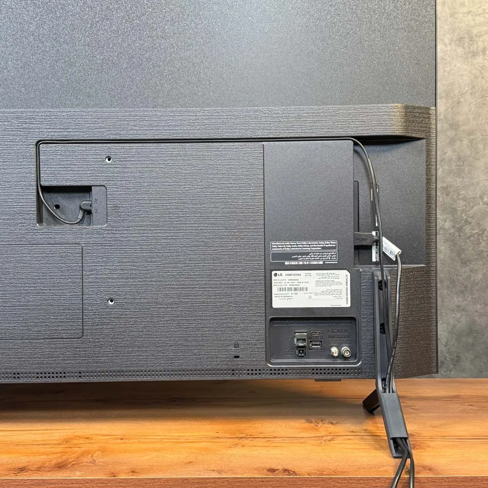 نمای پشتی تلویزیون ال‌ جی QNED82 با کابل‌کشی منظم و عبور کابل از داخل پایه