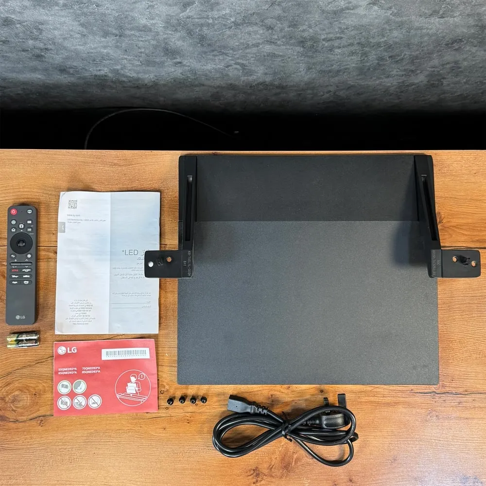 لوازم جانبی تلویزیون ال جی QNED93A شامل ریموت، باتری، پایه، پیچ، کابل و دفترچه راهنما